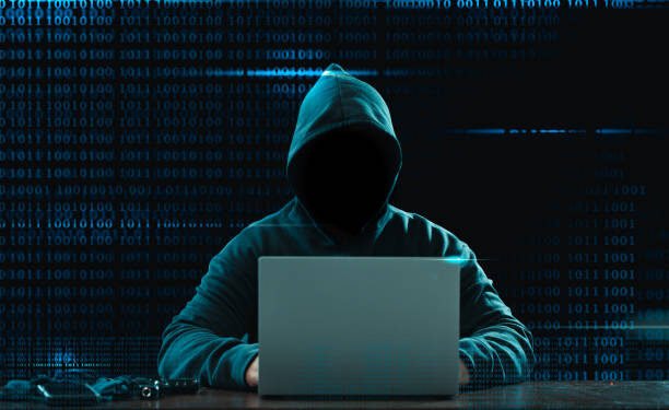 Big financial data theft concept. An anonymous hacker is hacking highly-protected financial data through computers.
