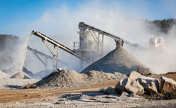 Industrial background - crusher rock stone crushing machine at open pit mining and processing plant for crushed stone, sand and gravel